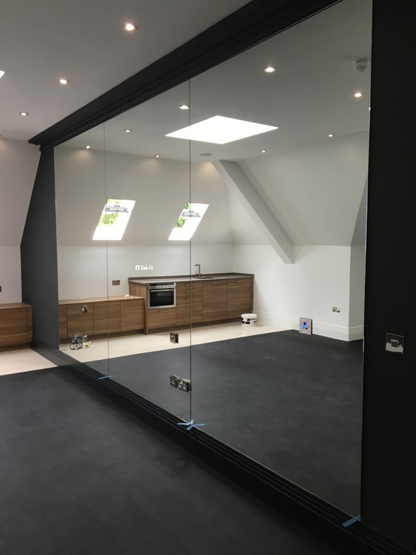 Frameless glass partition in loft conversion by Beaconsfield glaziers
