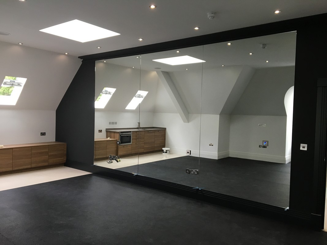 Frameless glass wall dividing loft conversion in Beaconsfield